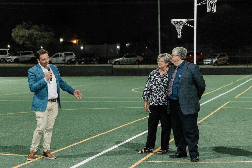 Man talking over microphone to the principle